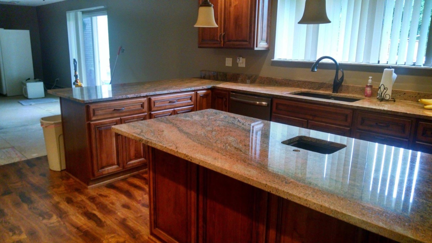 Remodeled kitchen with wood cabinets and granite island