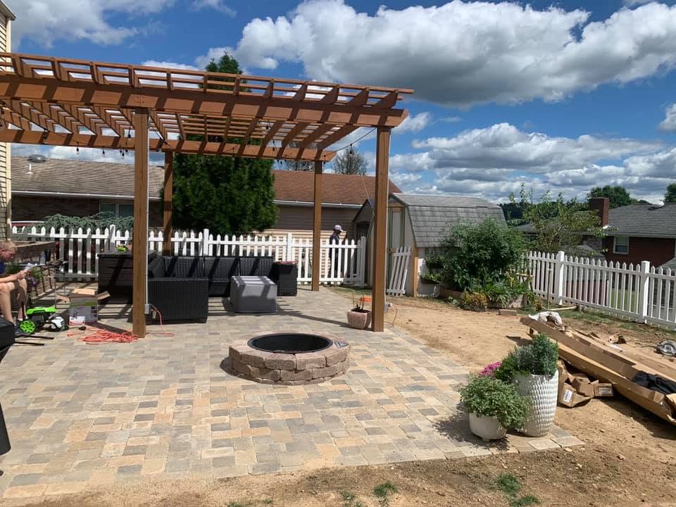 Paver patio with wood pergola and stone fire pit