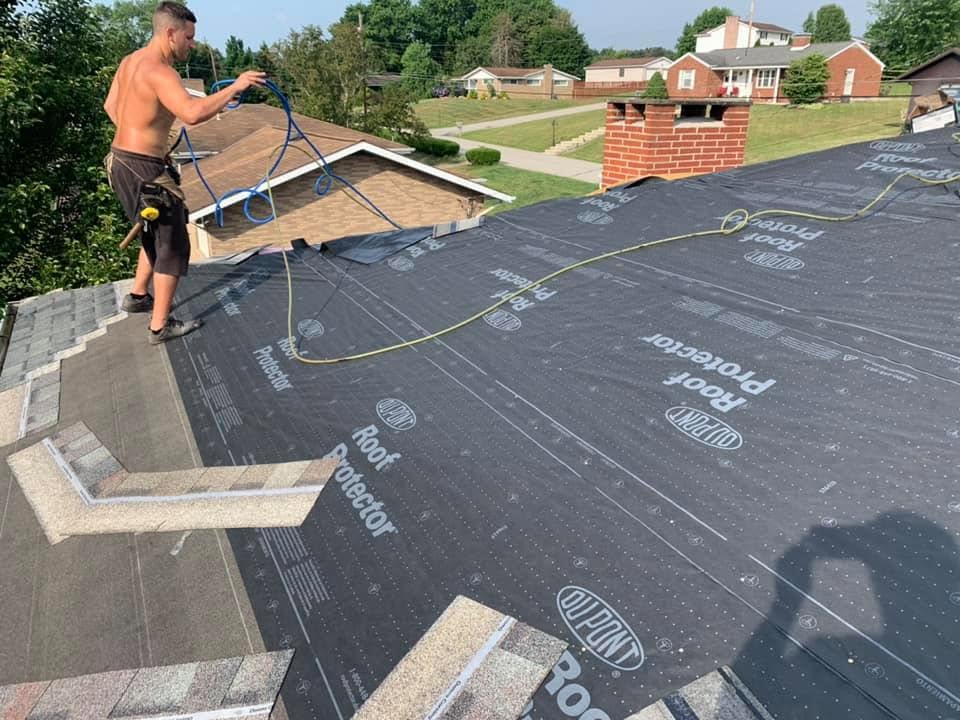 Roof tear-off with new underlayment being installed